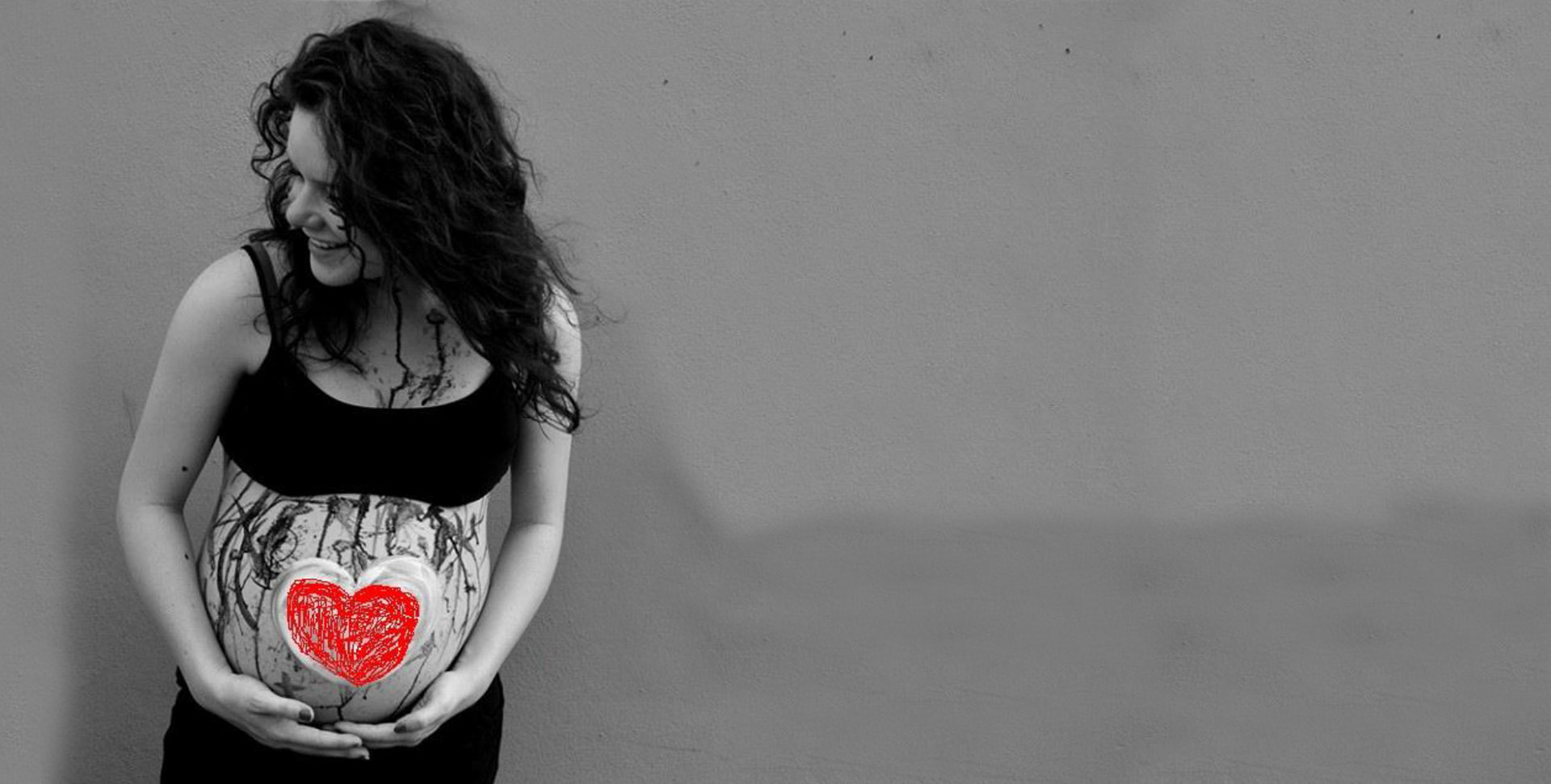 Una donna in attesa, con un cuore disegnato sul pancione